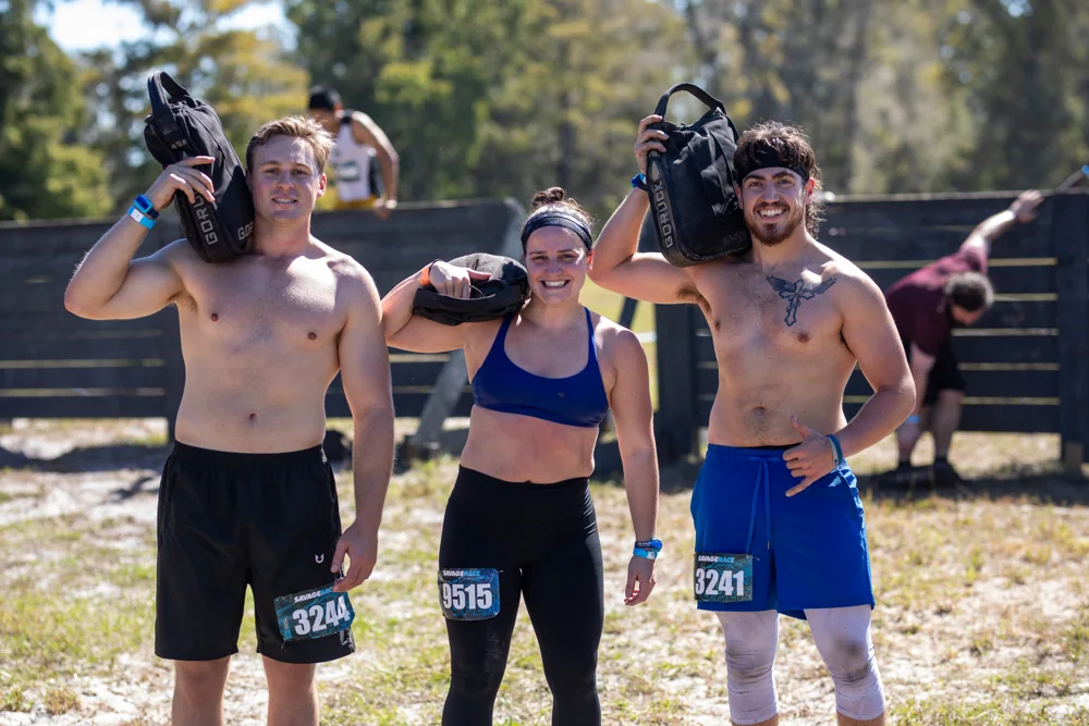 Friends take on a weighted carry together