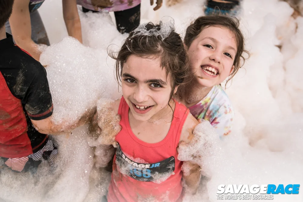 Two young SavageJR participants smile in the foam