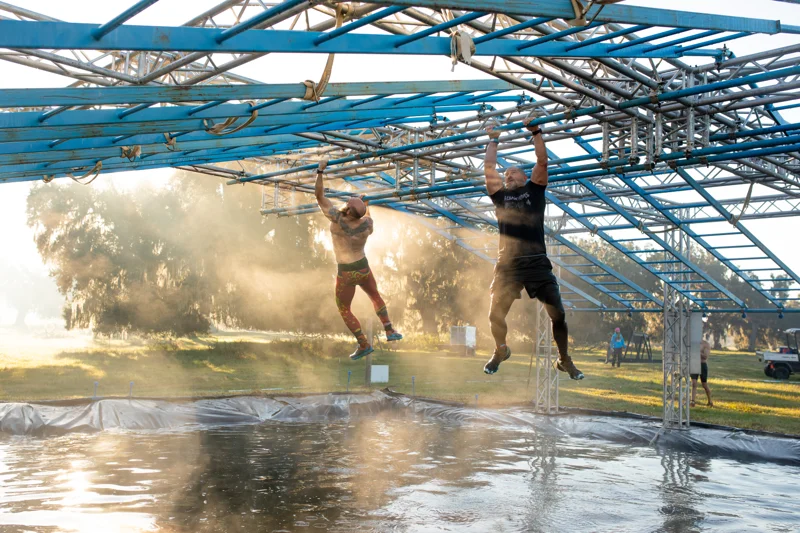 Athletes take on a huge blue obstacle above the water