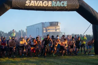 Racers gather under the Savage Race starting arch