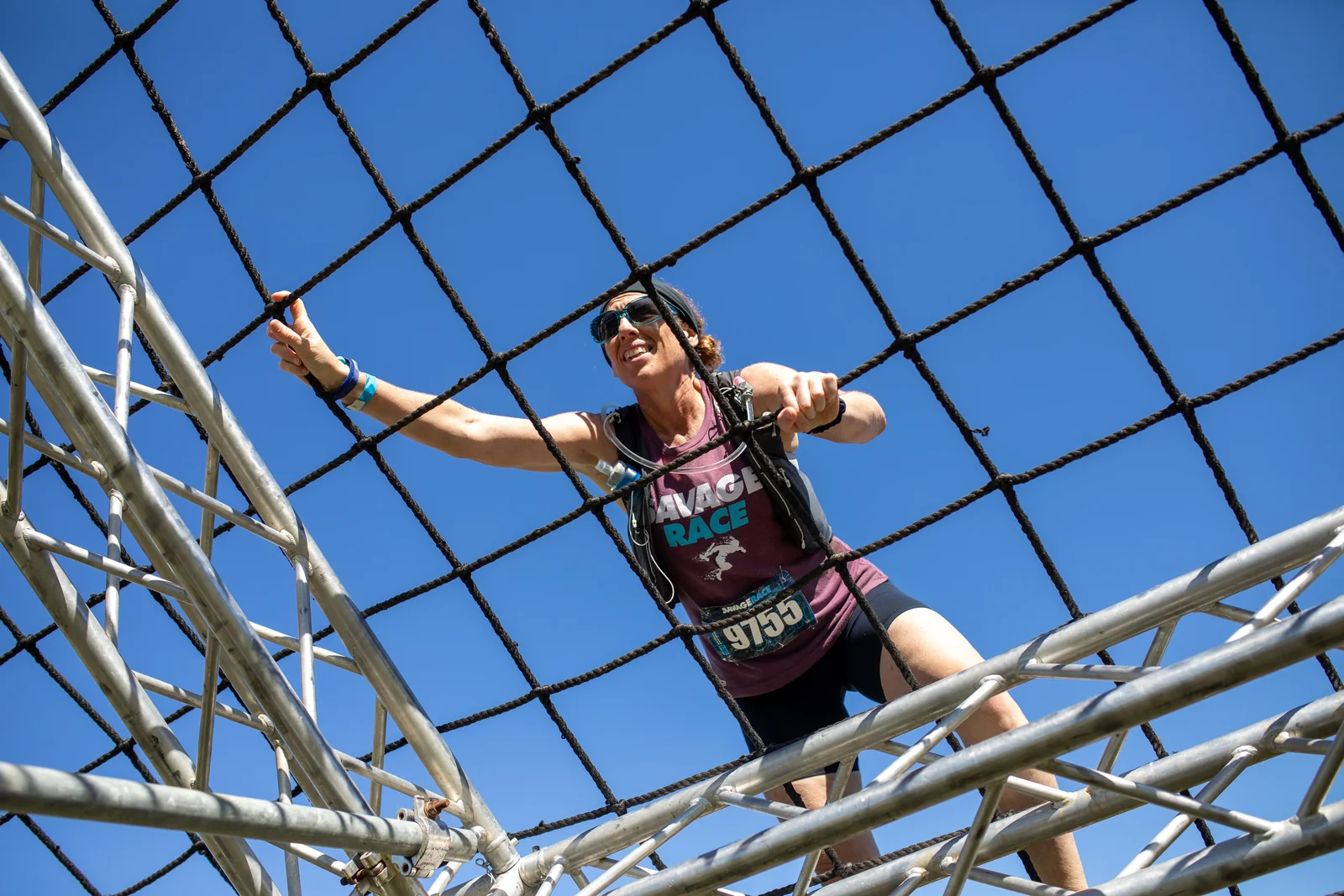 A racer climbs a cargo net above the camera