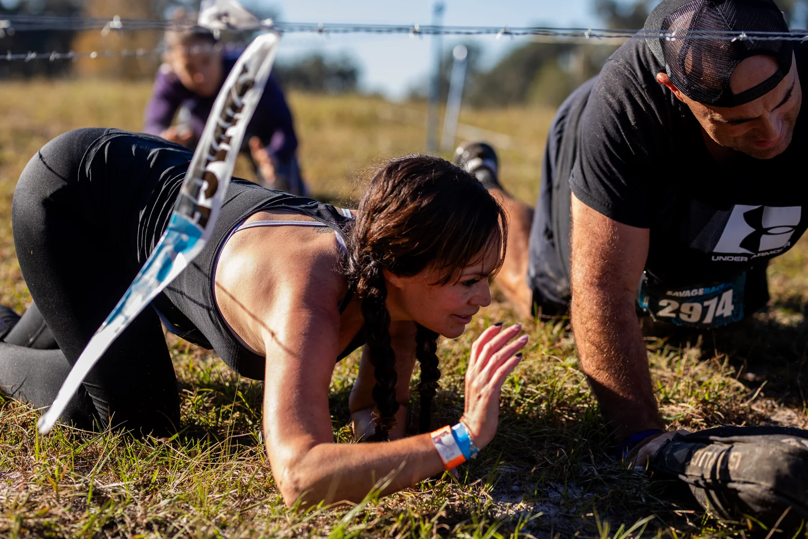 Racers work together to climb over hanging tires