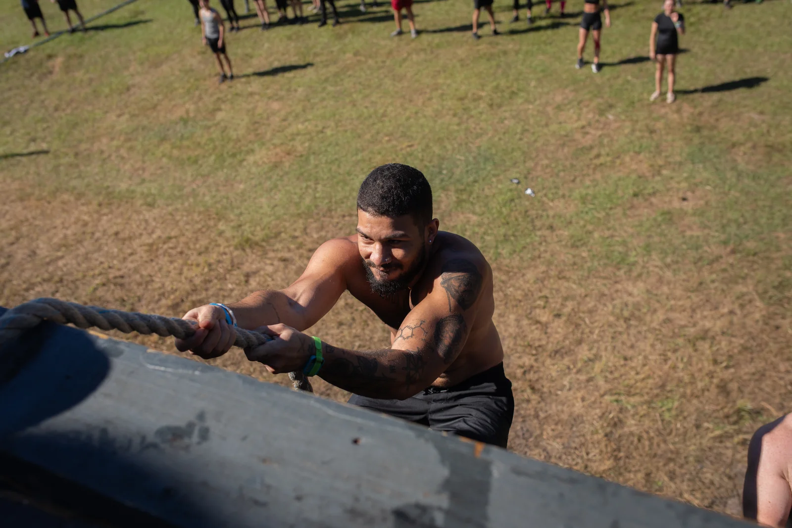 A racer pulls up a steep ramp using a rope