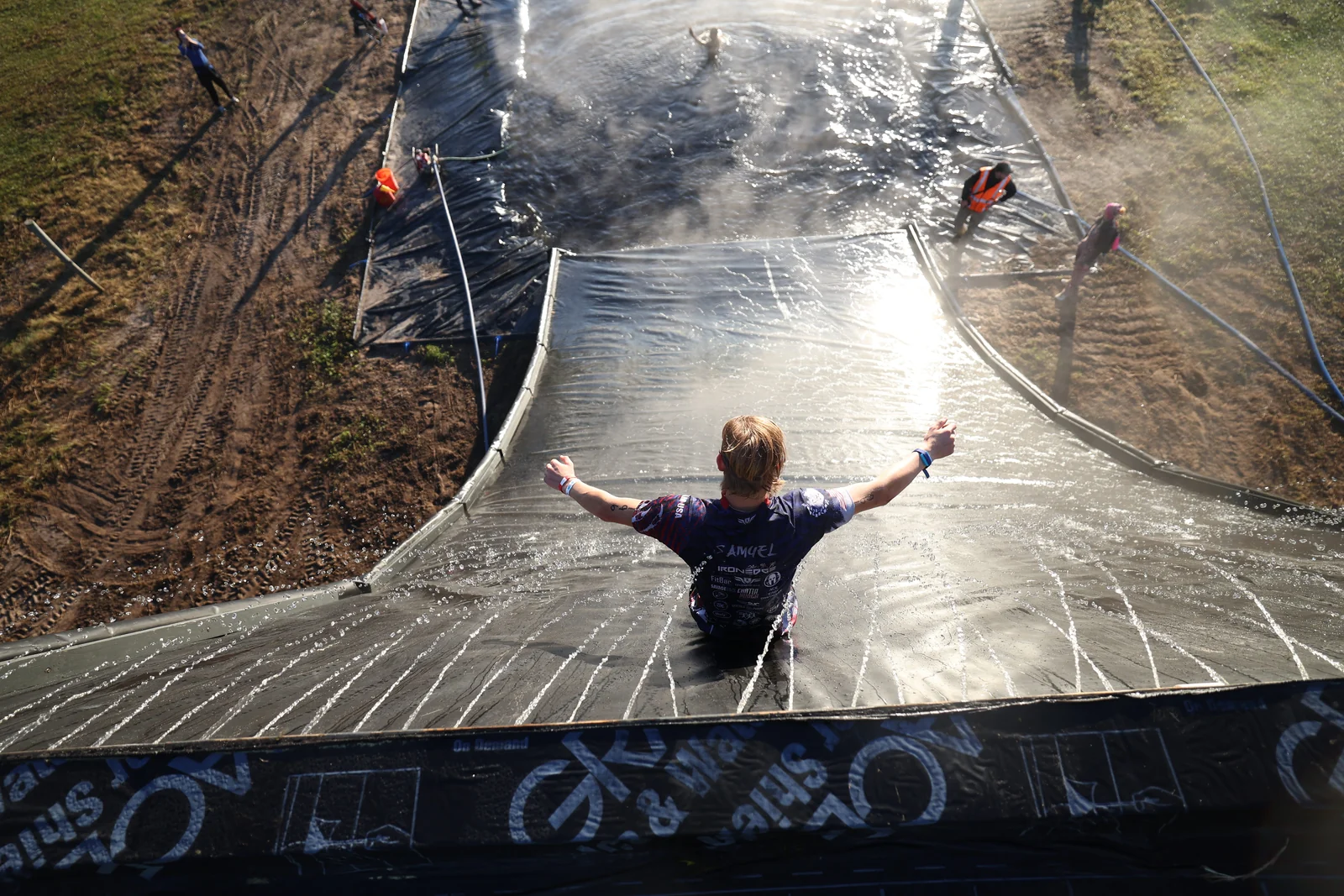 A racer throws their arms wide on a giant waterslide