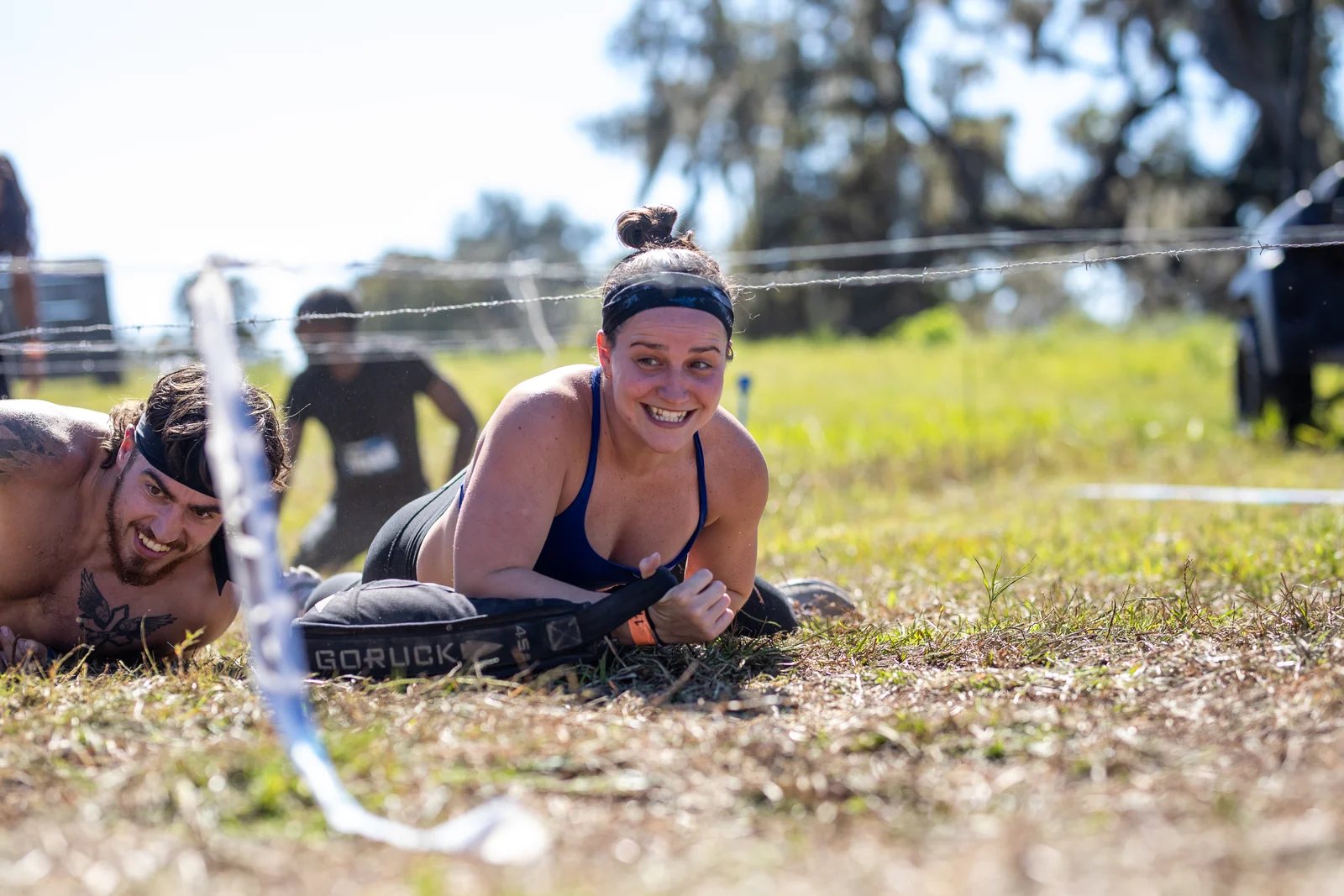 Two racers smile while crawling under the wire